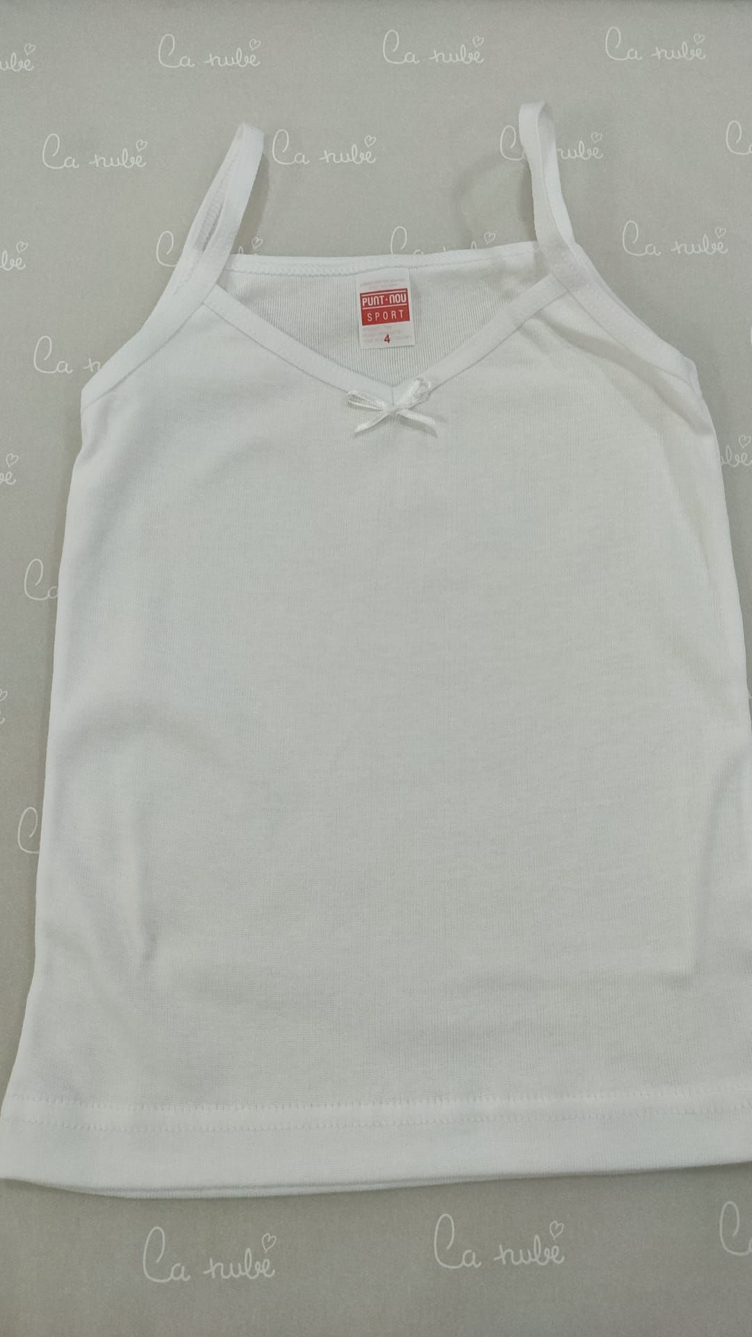 Una camiseta blanca sin mangas está sobre una mesa.