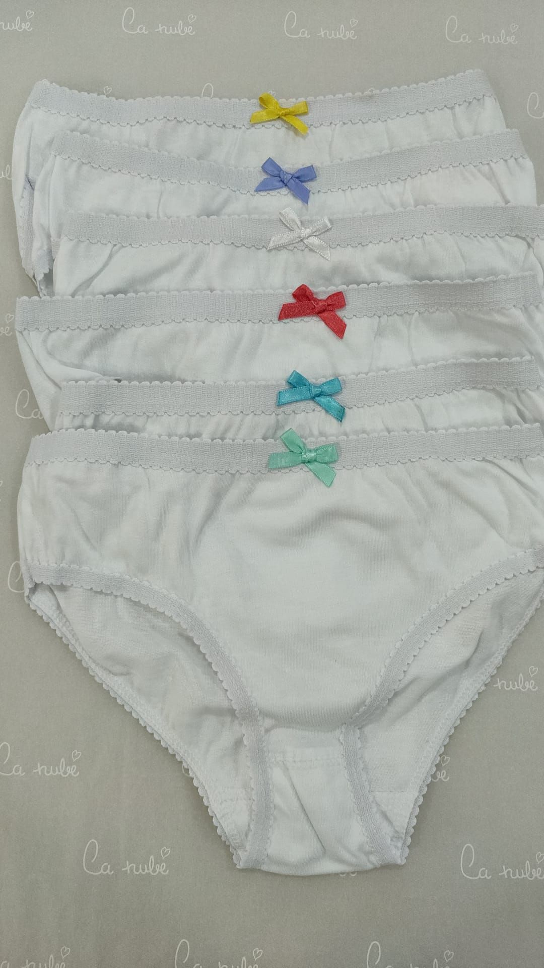 Una pila de ropa interior blanca con lazos de colores.