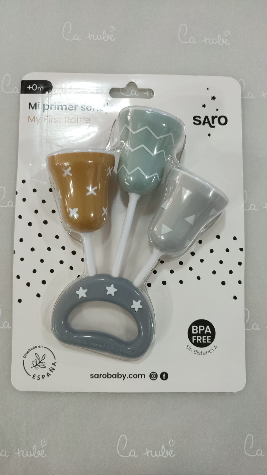 Un sonajero de bebé está sobre una mesa dentro de un paquete.