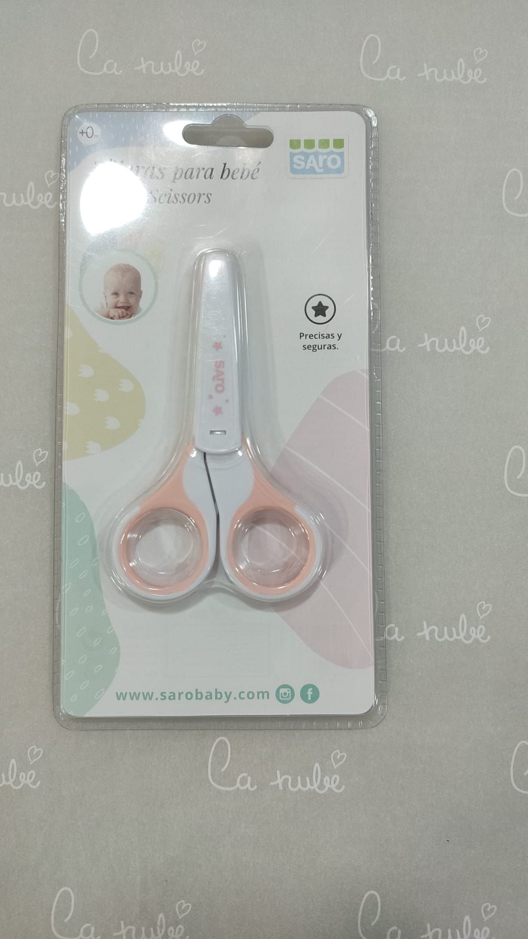 Un par de tijeras de bebé en un paquete sobre una mesa.