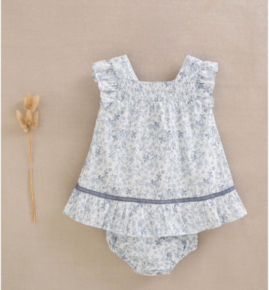 Una niña lleva un vestido floral y pantalones bombachos.