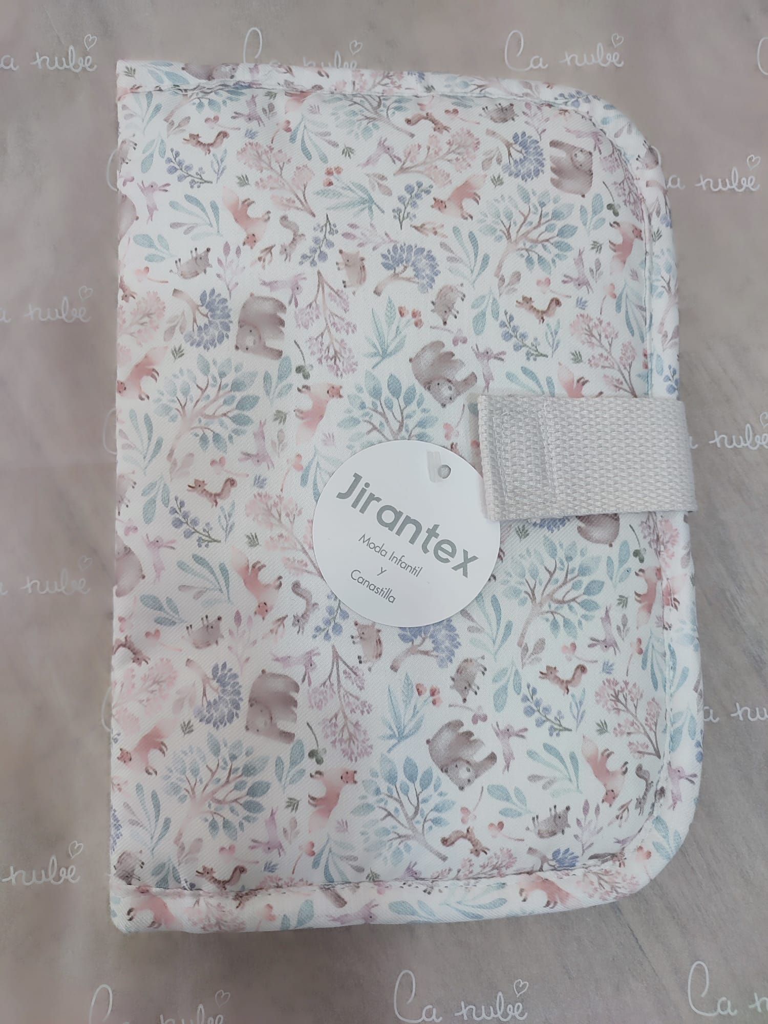 Un libro de bebé con un estampado floral está sobre una mesa.