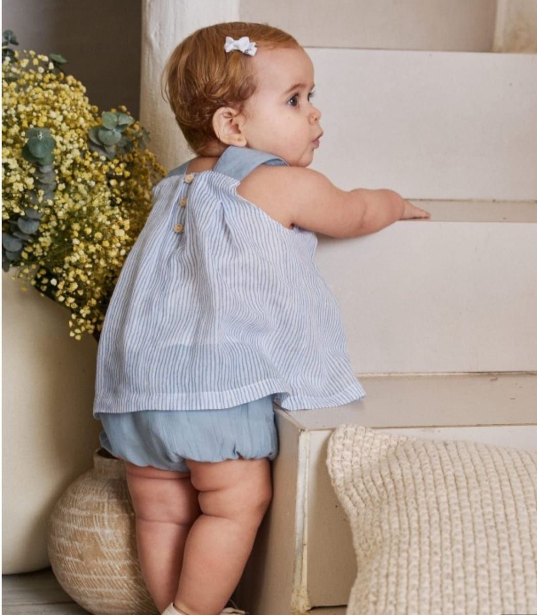 Una niña está de pie junto a unas escaleras.