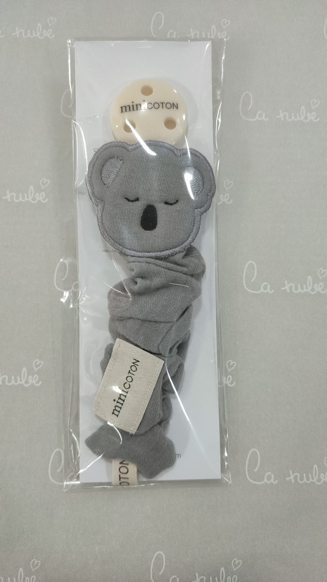 Un clip para chupete con un koala envuelto en plástico.