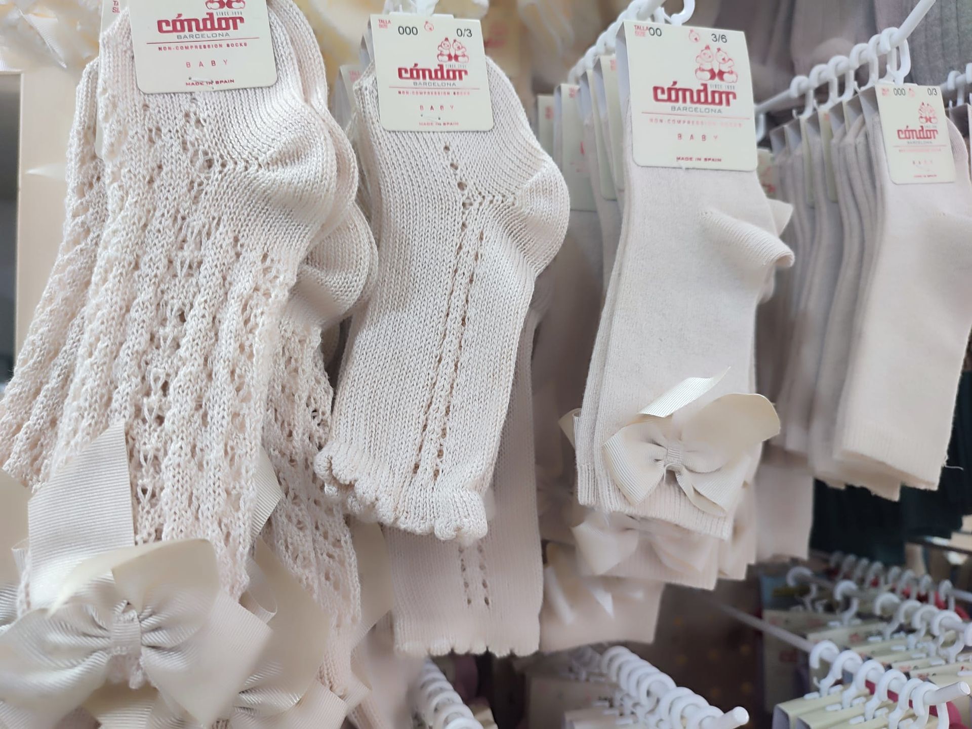 Un montón de calcetines blancos están colgados en un estante en una tienda.