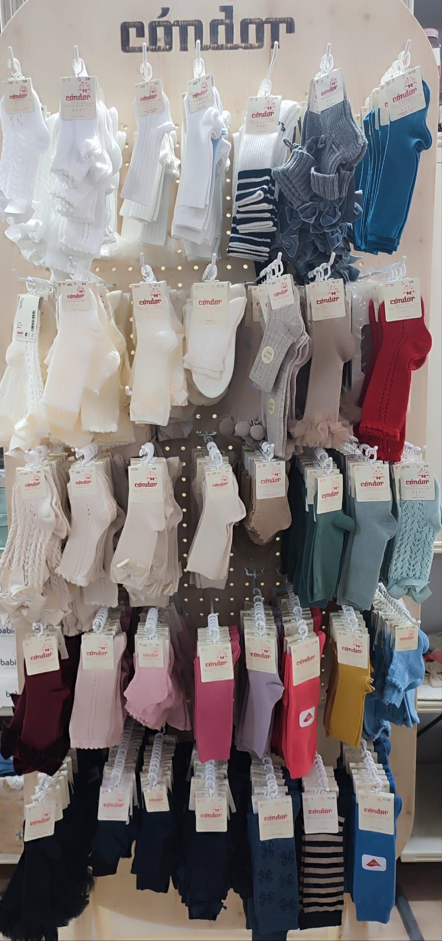 Una exhibición de calcetines colgados en un estante en una tienda.