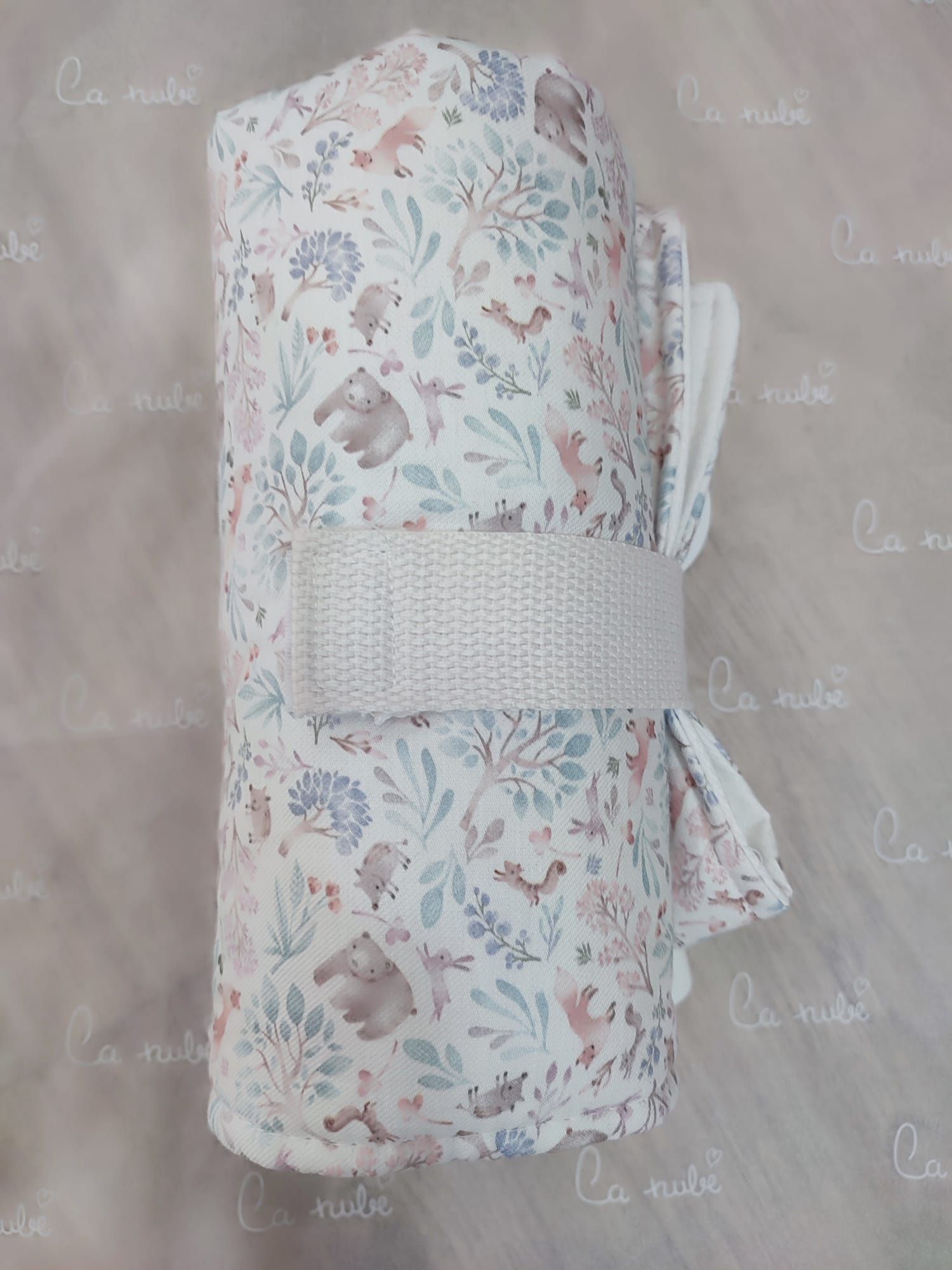 Una manta con un estampado floral está enrollada sobre una mesa.