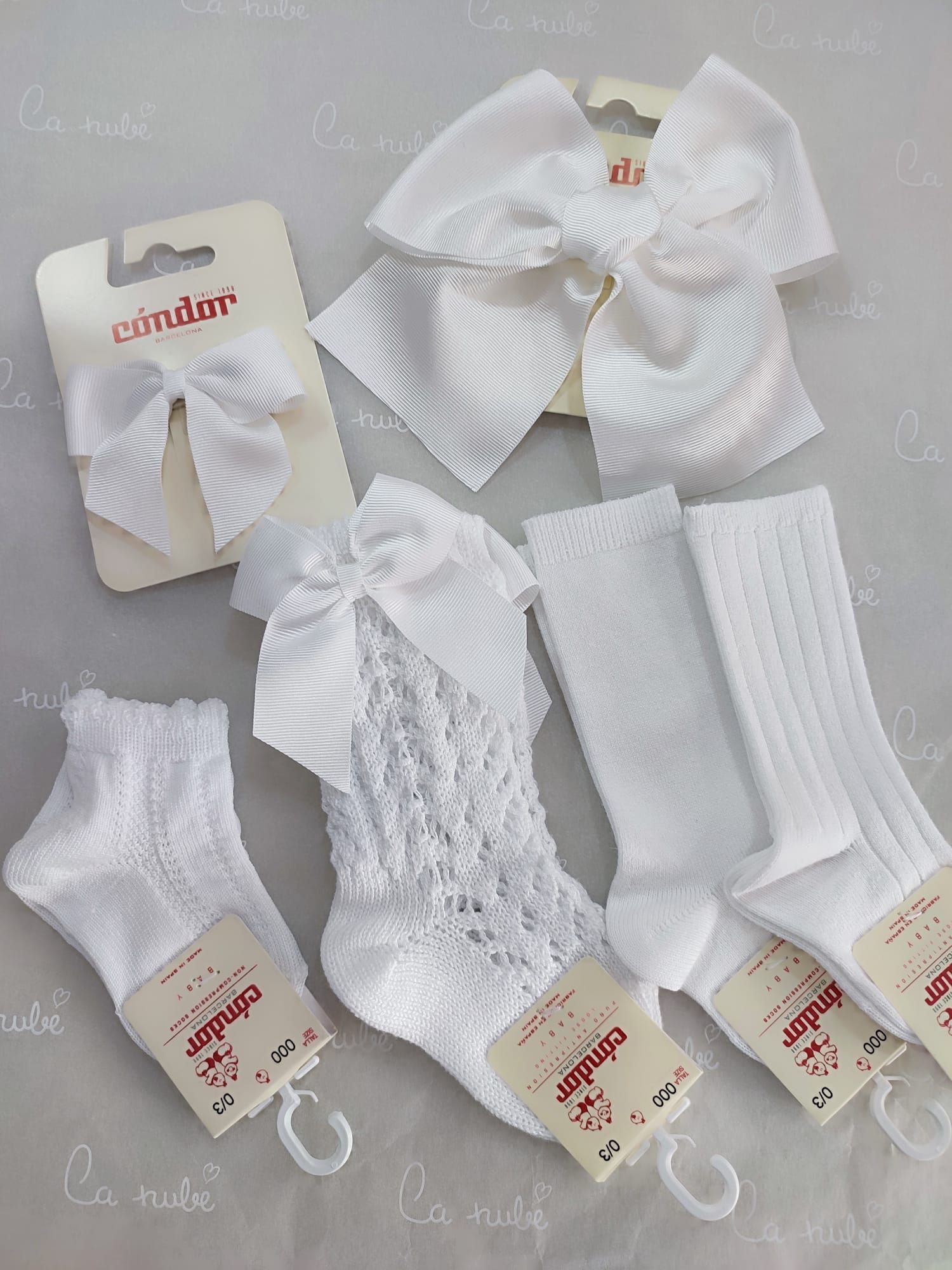 Un montón de calcetines blancos y lazos están sobre una mesa.