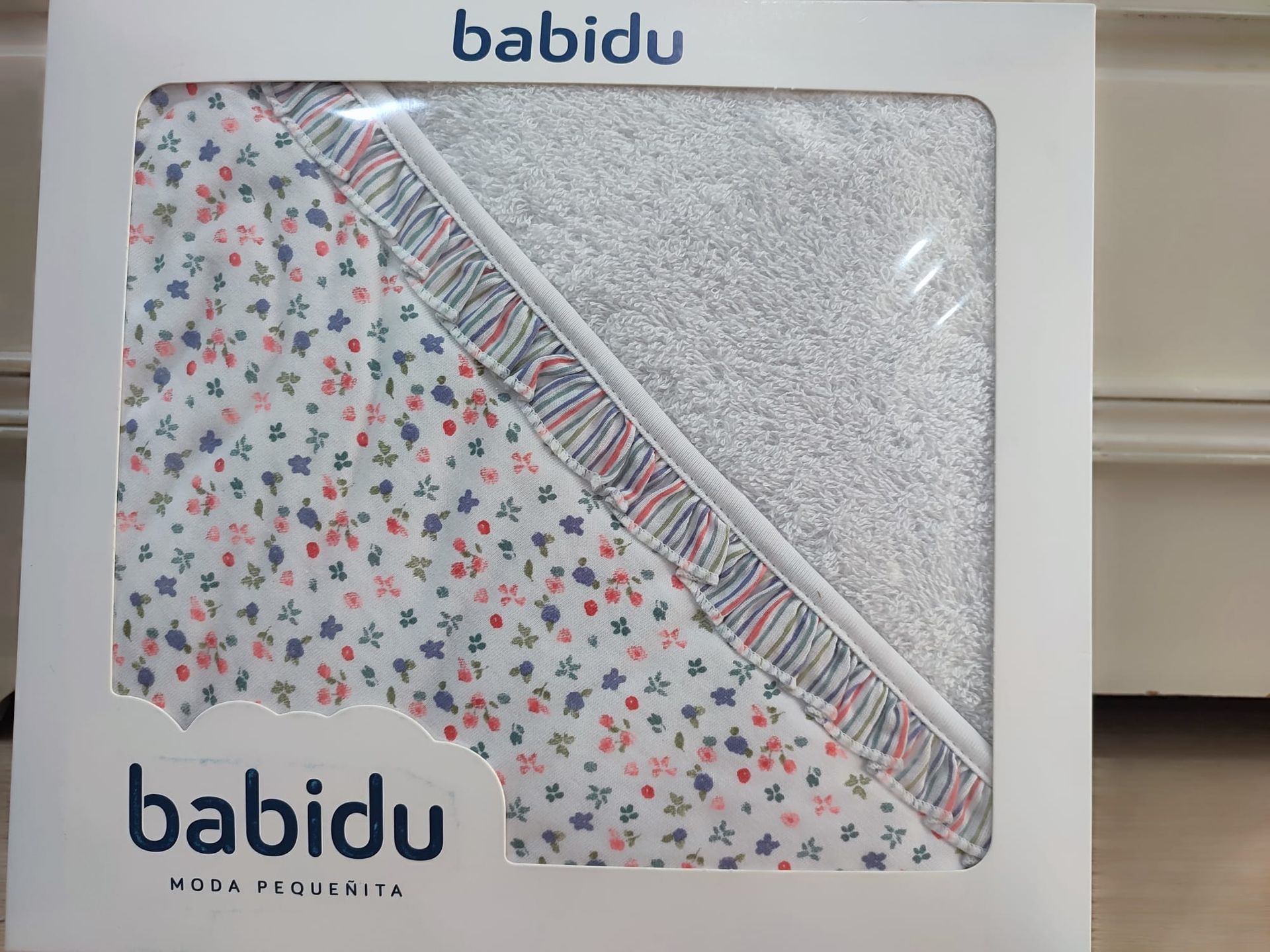 Una toalla con capucha para bebé viene en una caja de Babidu.