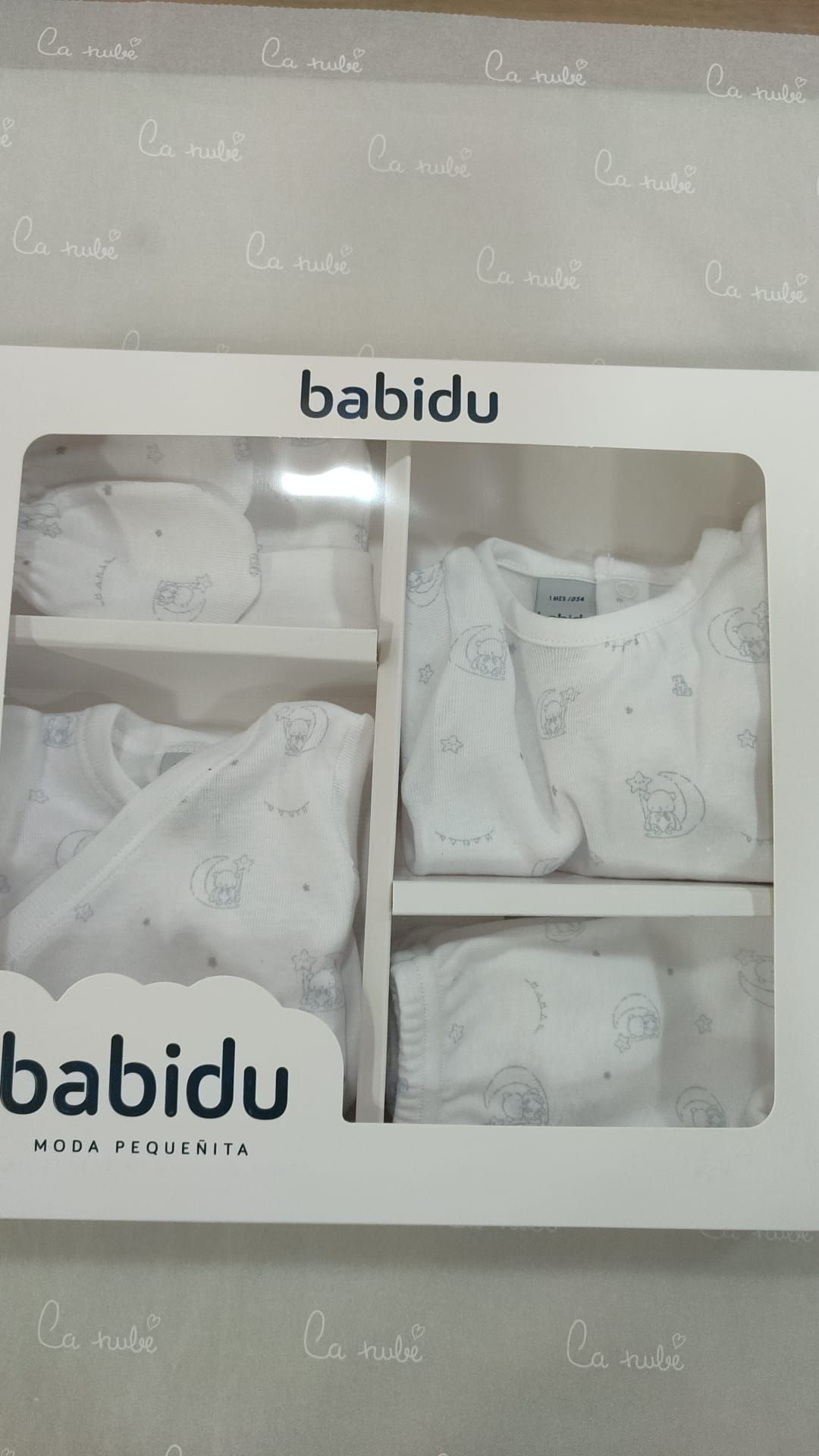 Una caja de ropa de bebé babidu está sobre una mesa.