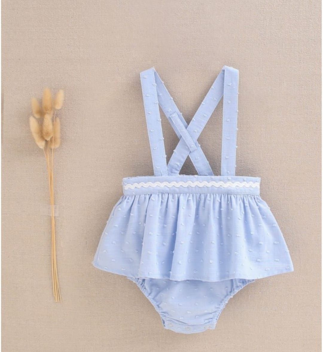 Una niña lleva un vestido azul claro con tirantes.