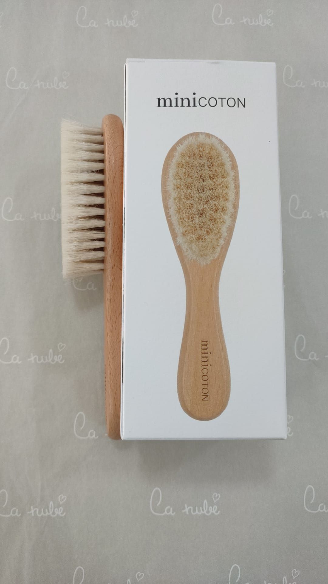 Un cepillo de bebé está junto a una caja sobre una mesa.