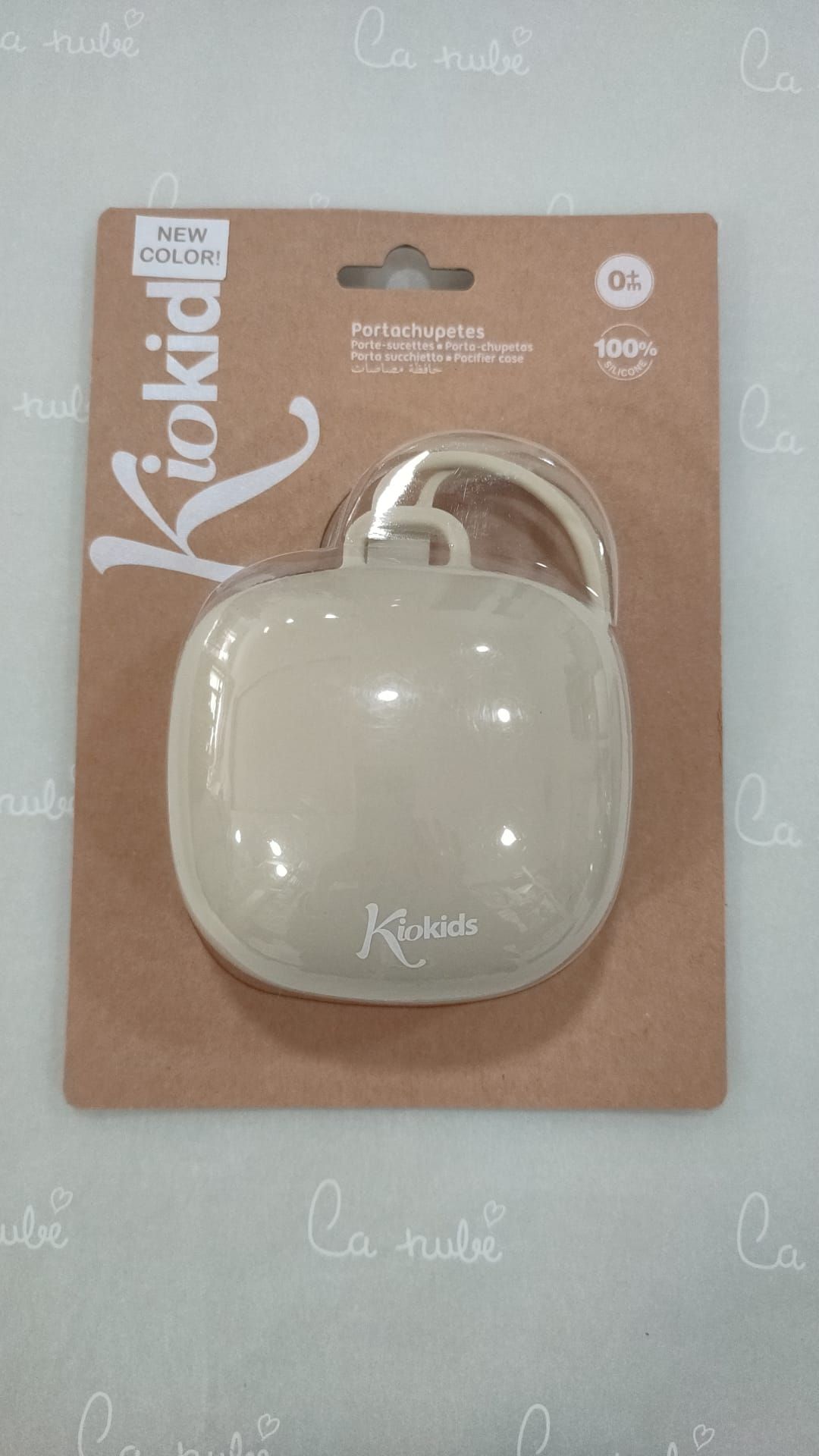 Un porta chupete está sobre una mesa dentro de un paquete.