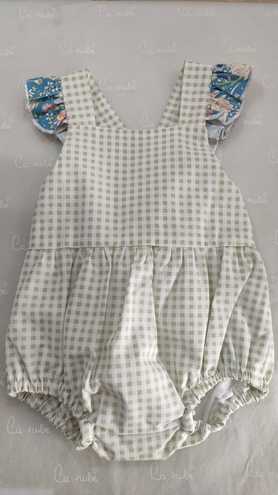 Una niña lleva un mono con mangas con volantes.