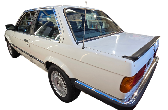Berline BMW blanche avec aileron arrière.