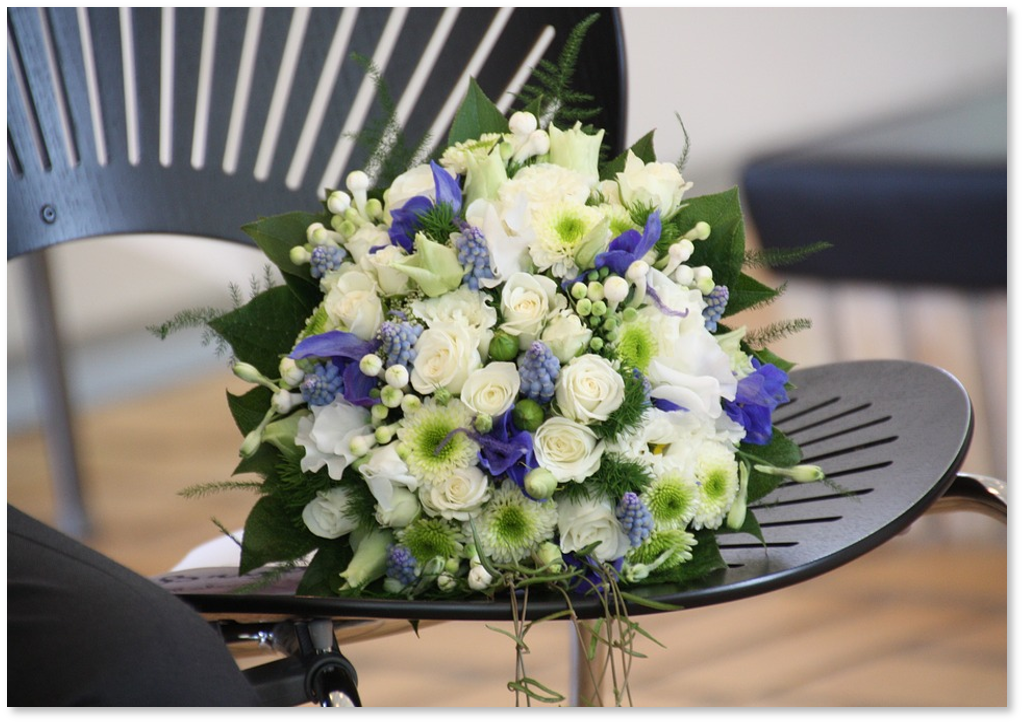 Bouquet de fleurs blanches et violettes sur une chaise noire.
