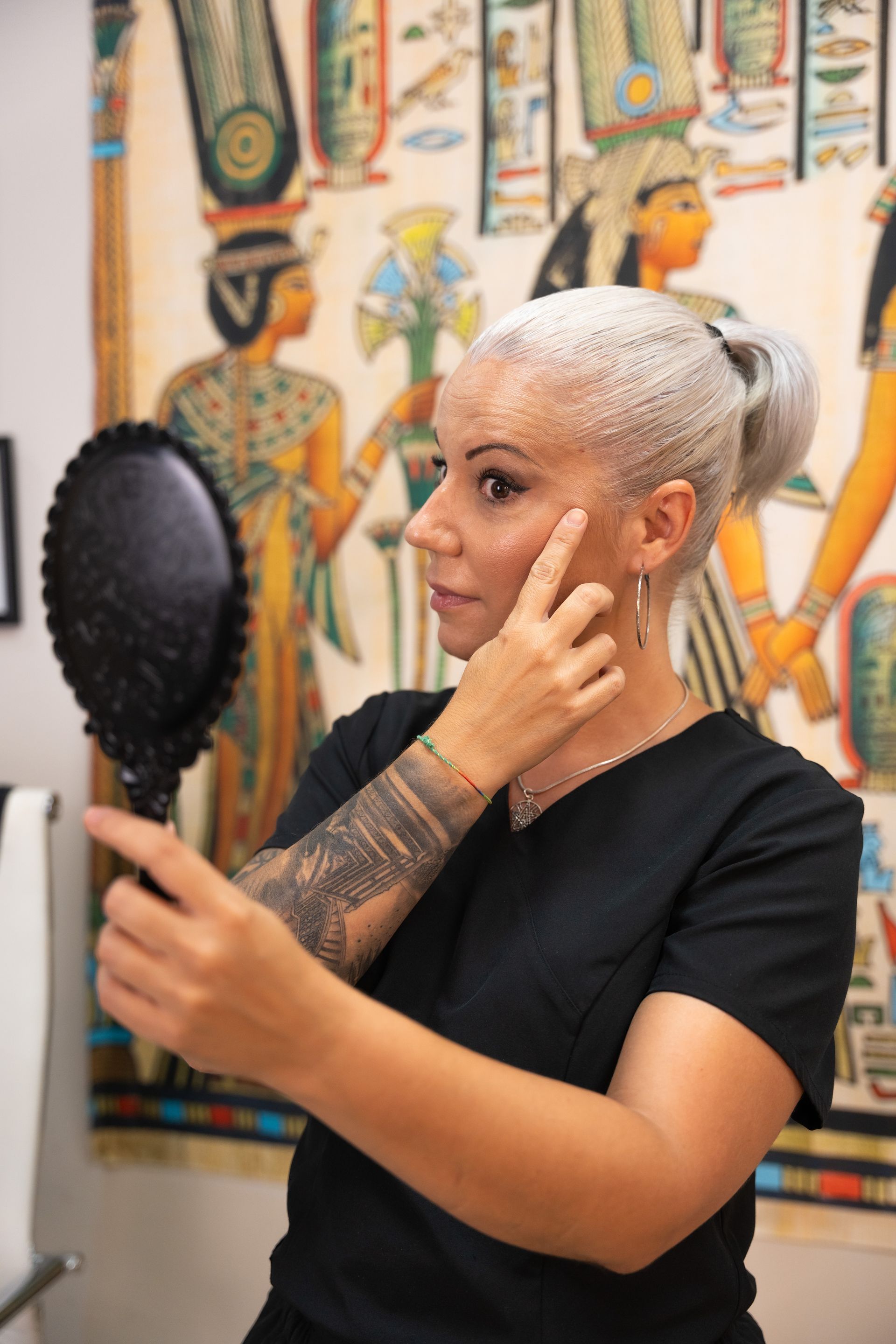 Una mujer se mira la cara en un espejo.