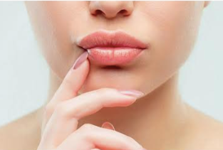 Un primer plano del rostro de una mujer con un dedo en los labios.