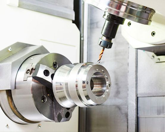 Una máquina está cortando una pieza de metal en una fábrica.