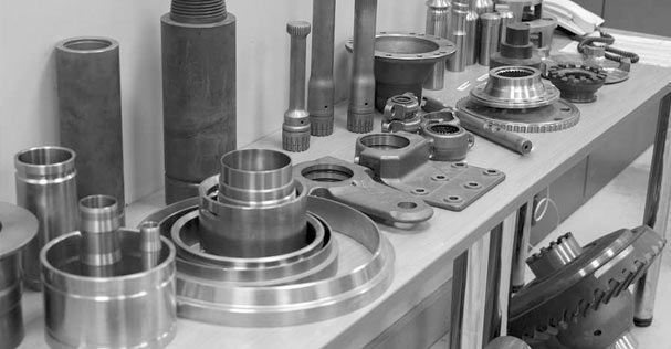 Una fotografía en blanco y negro de una mesa llena de piezas de metal.