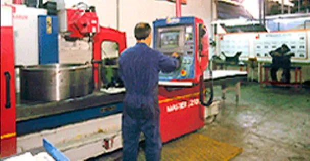Un hombre está trabajando en una máquina en una fábrica.