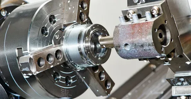 Una máquina está cortando un trozo de metal en un torno.