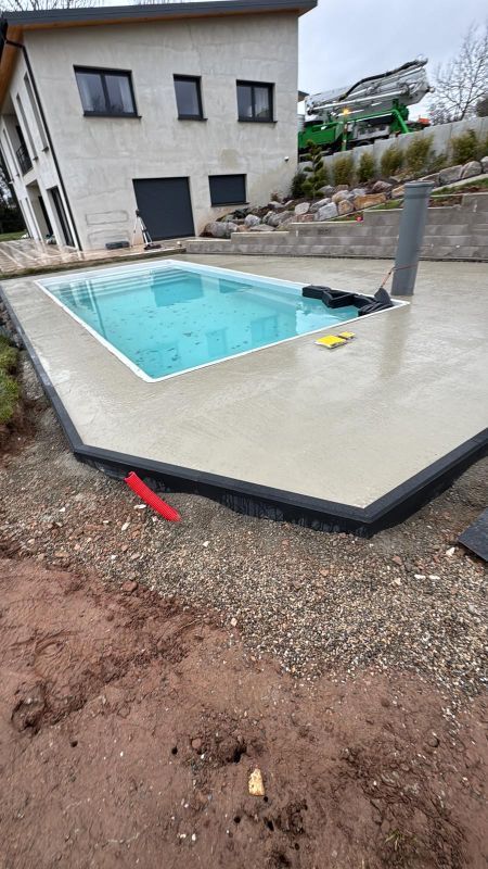Terrasse arrière avec une petite piscine rectangulaire à côté d'une maison en construction