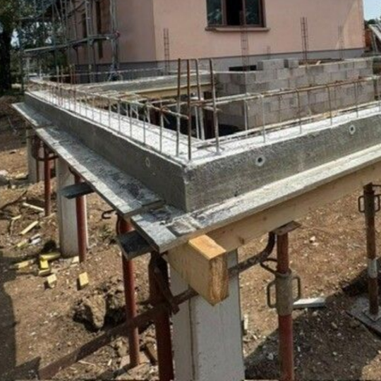 Fondation en béton en construction avec armatures et supports en bois sur un chantier