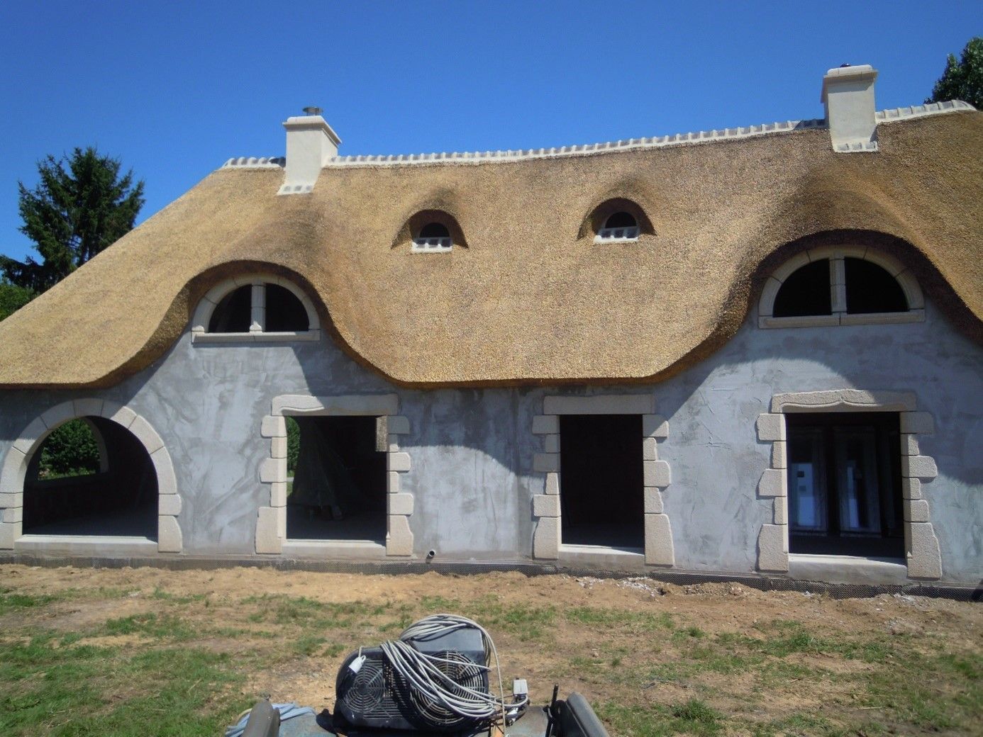 Encadrement en pierre de toutes les ouvertures d'une maison au toit de chaume : fenêtres, portes, portes-fenêtres…