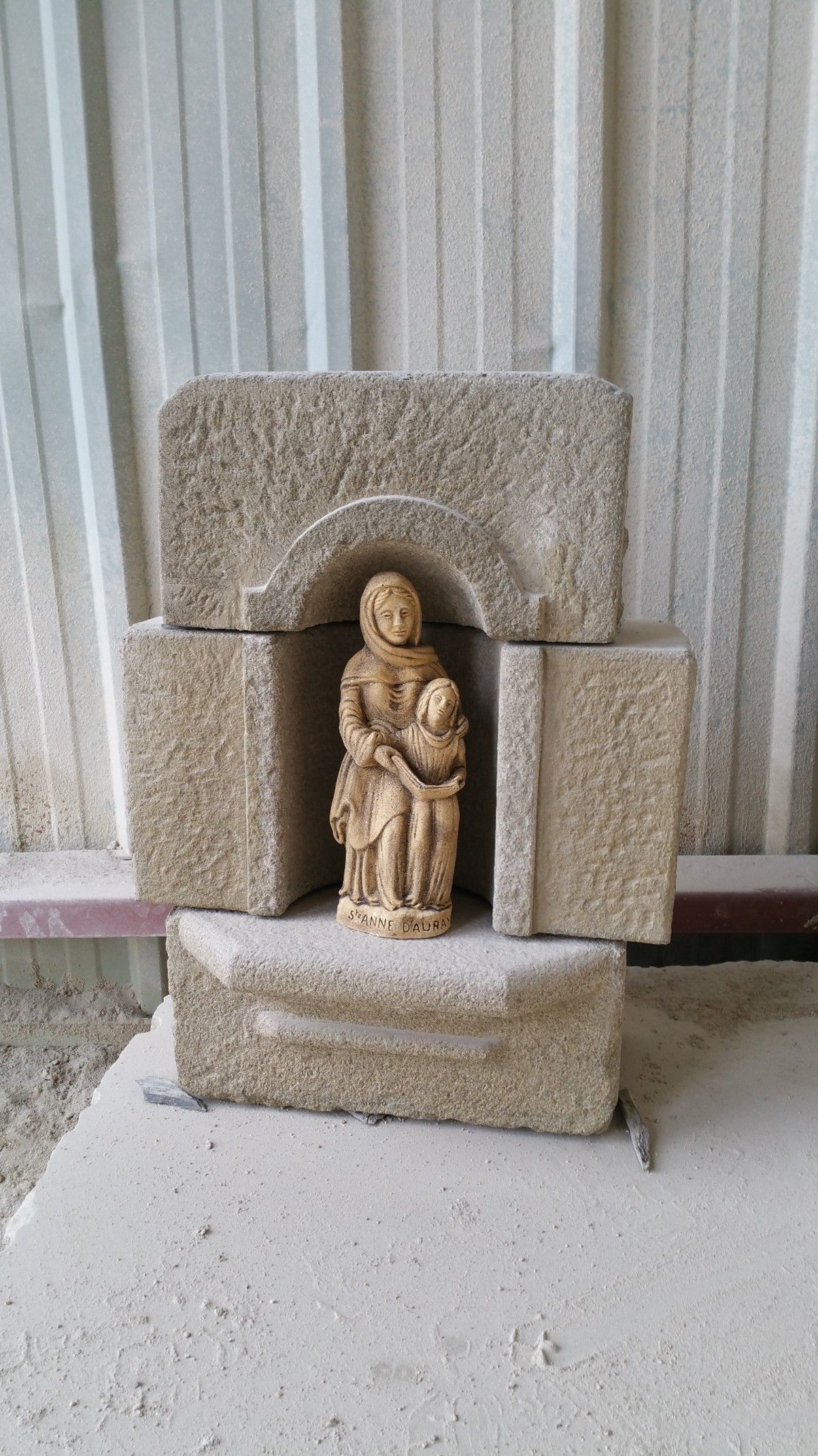 Sculpture de St Anne d'Auray avec un enfant et un livre ouvert.