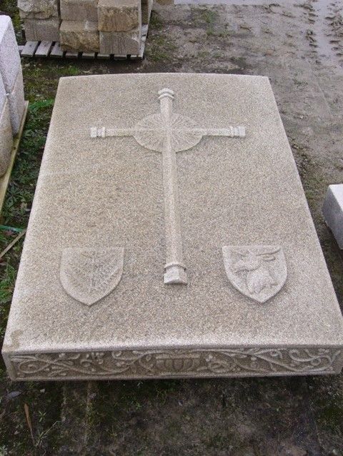 Sépulture, pierre tombale en pierre avec une croix sculptée dessus.