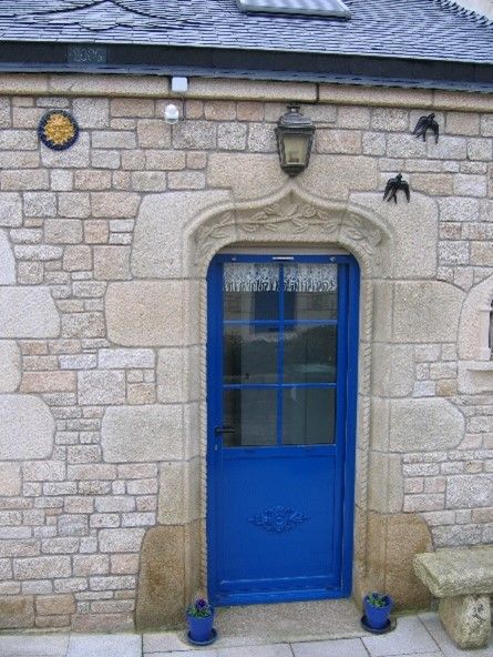 Tour d'une porte bleue en pierre avec des motifs.