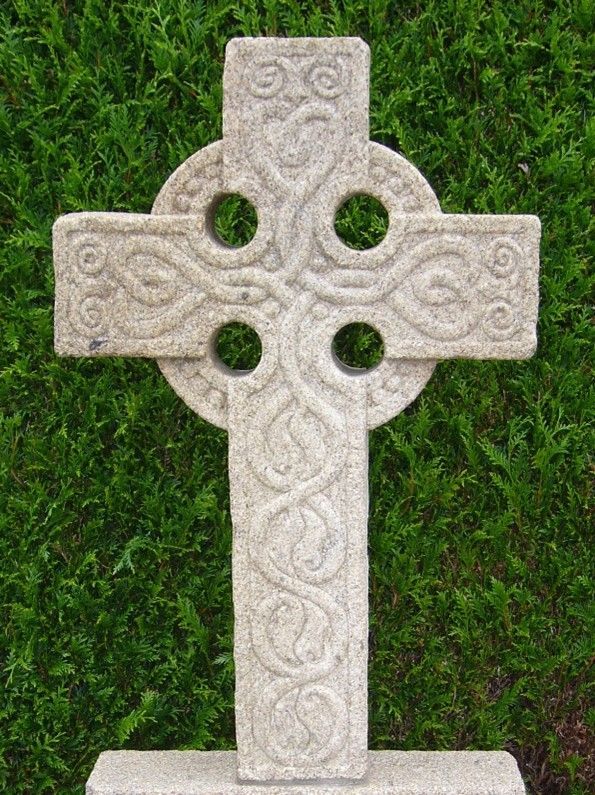 Croix celte avec 4 trous et des ornements sculptés dessus.