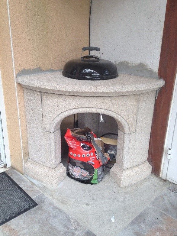 Four en pierre extérieur avec un sac de charbon devant.