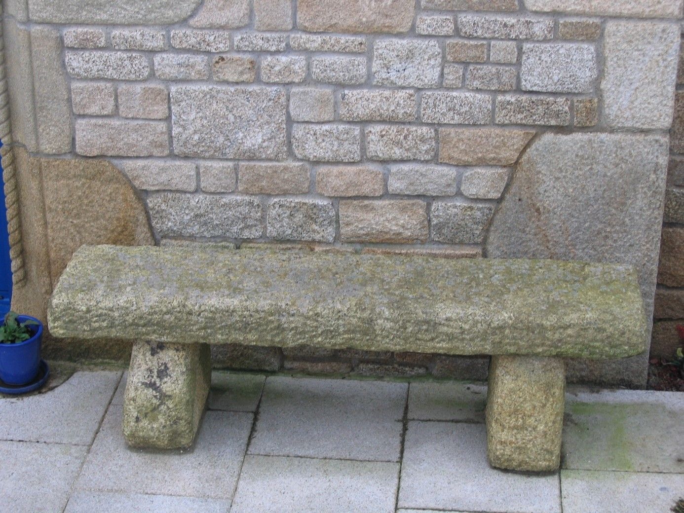 Banc en pierre avec des pieds en forme arrondie.