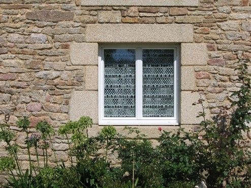 Fenêtre blanche avec un tour en pierre.