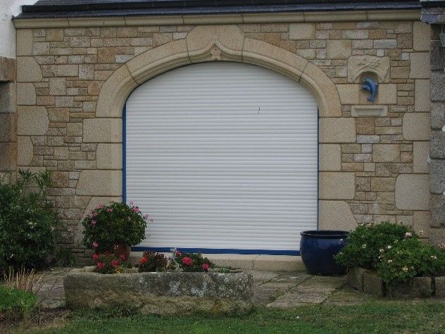 Grande baie vitrée avec un tour en pierre en forme arrondi.