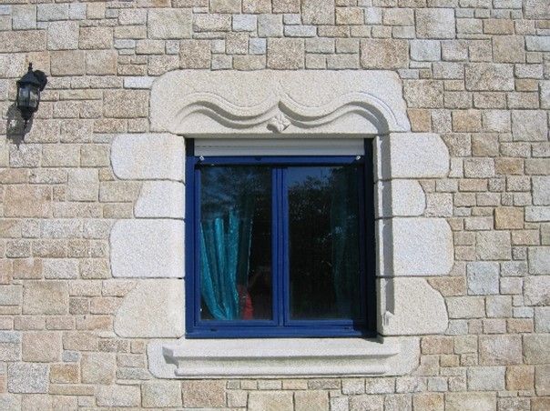 Tour de fenêtres en grosses pierre avec des motifs et une étoile.