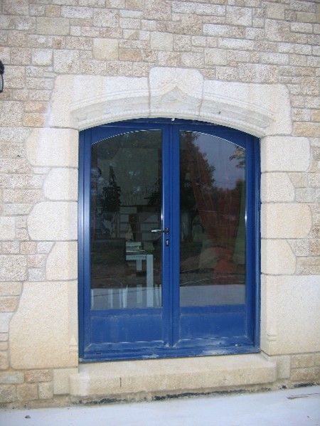 Porte-fenêtre bleue avec un tour en pierre.
