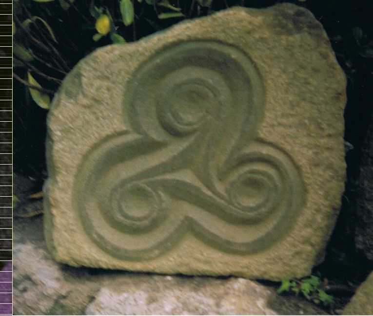 Sculpture d'une forme celte avec trois embouts qui s'enroulent sur eux-mêmes.