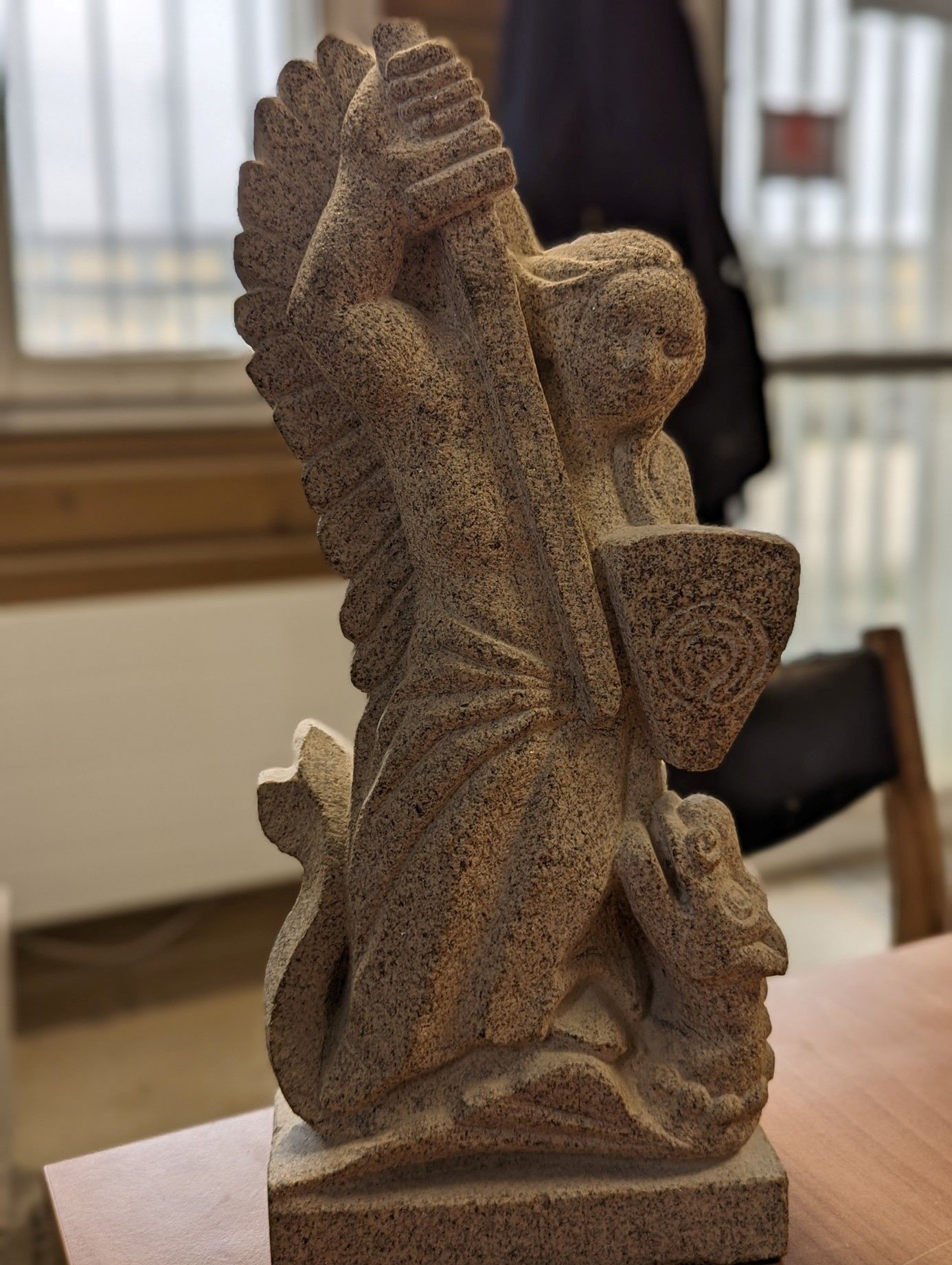 Sculpture de l'ange terrassant le dragon avec son épée et son bouclier.