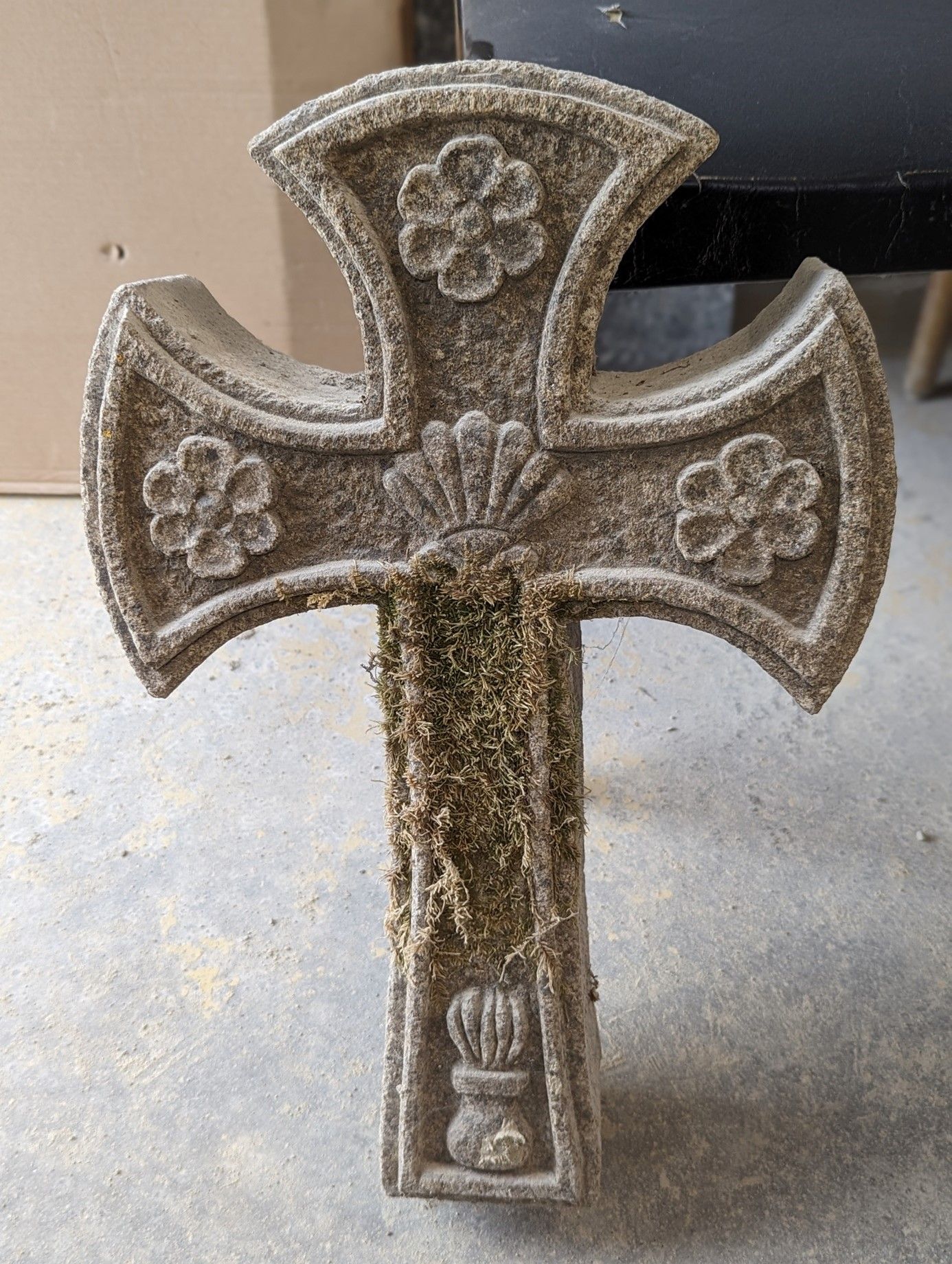 Croix celte avec les bouts arrondis et des fleurs et coquillages sculptés.