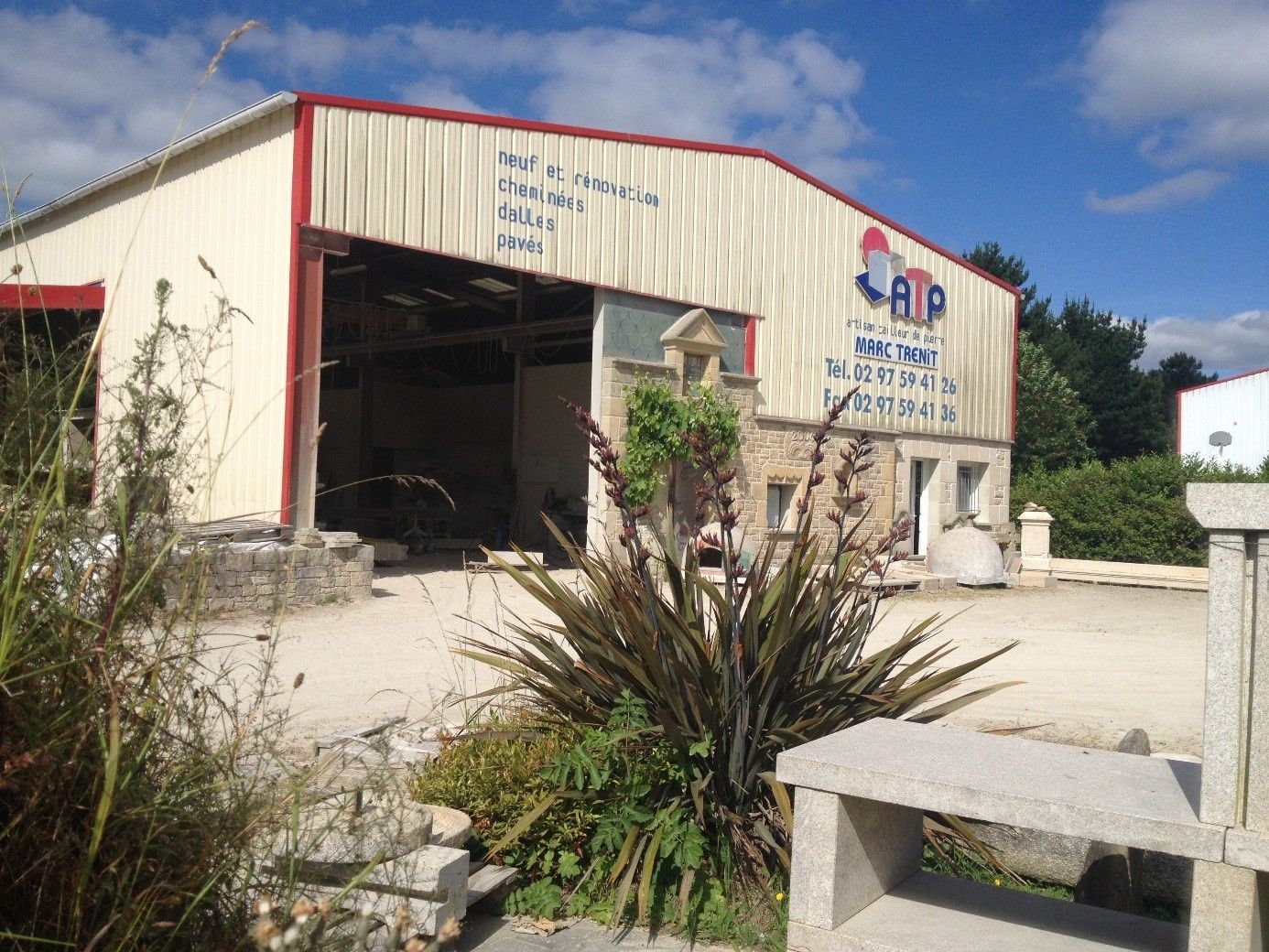 Atelier de l'entreprise, grand bâtiment beige.