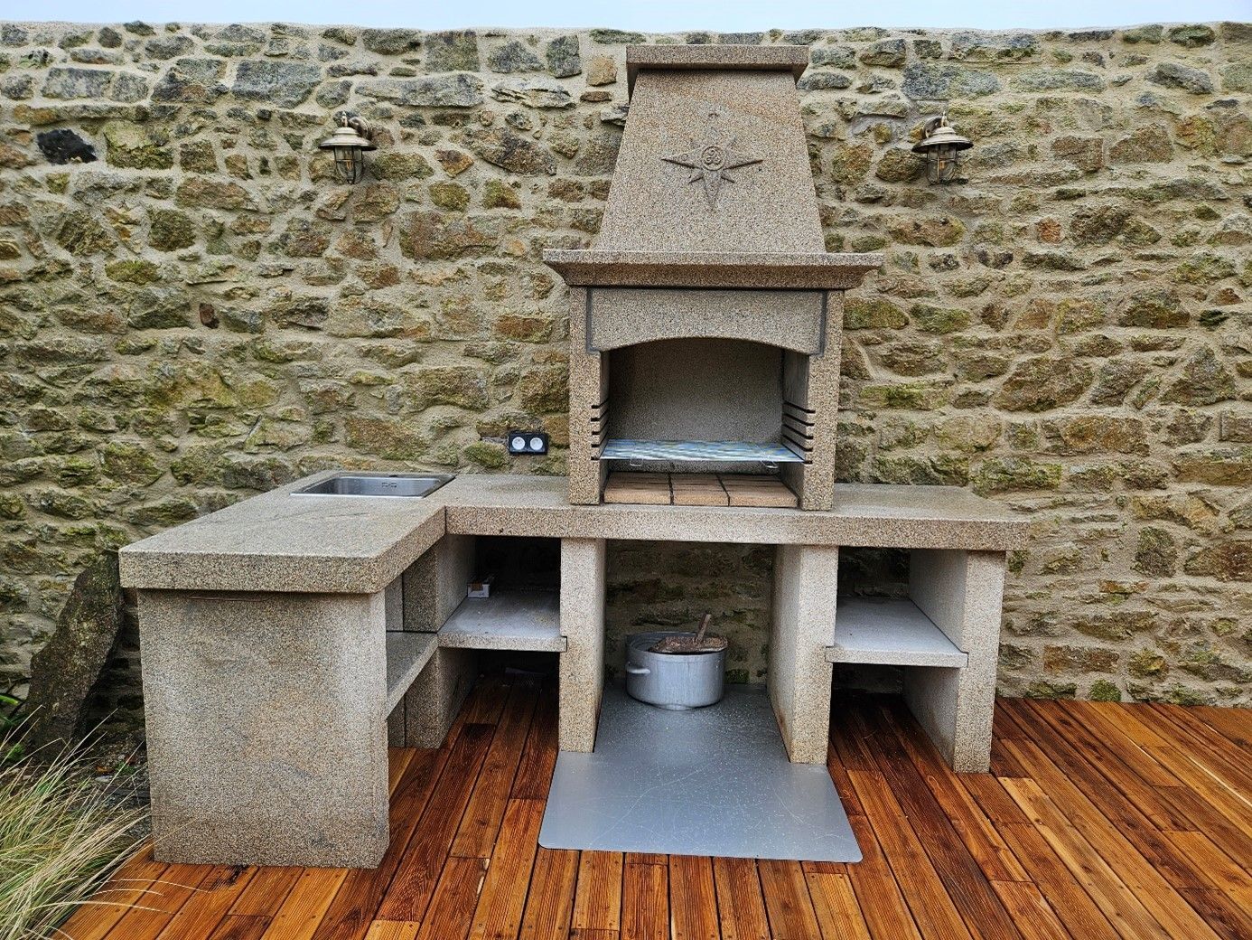 Barbecue d'angle en pierre avec des rangements.