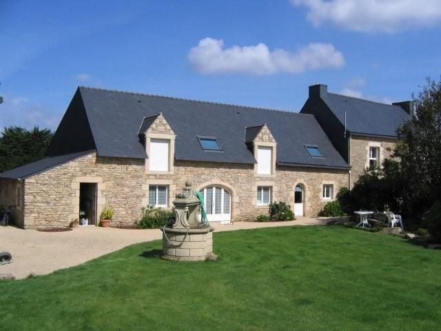 Rénovation de la façade d'une ferme en pierre avec un puits