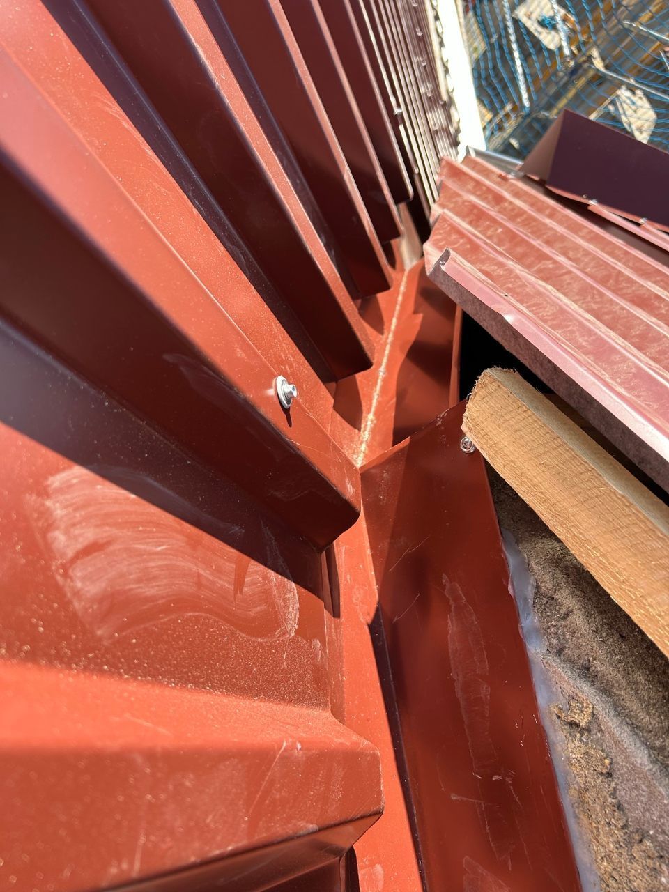 Eine Nahaufnahme einer roten Wand mit einer Schraube darin. Foto von Ulrich Gerber Rund Ums Dach