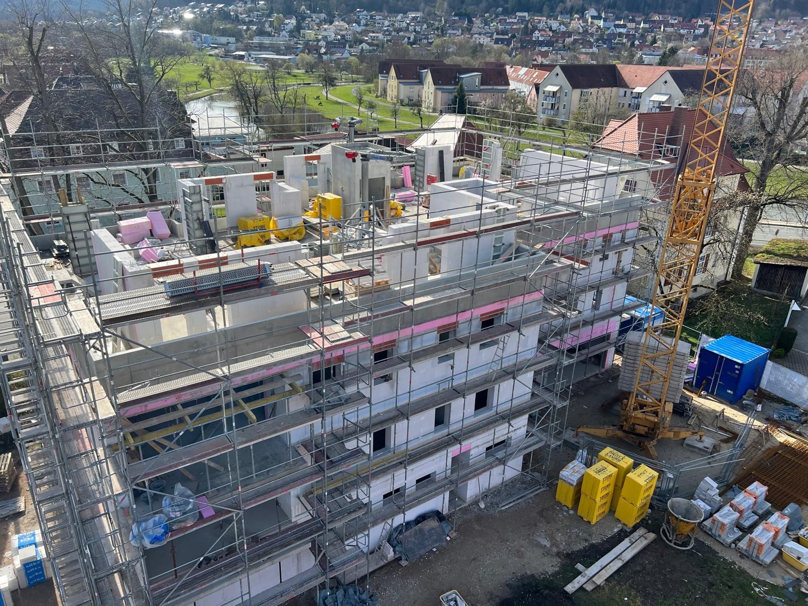 Eine Luftaufnahme eines im Bau befindlichen Gebäudes mit Gerüst und Kran.