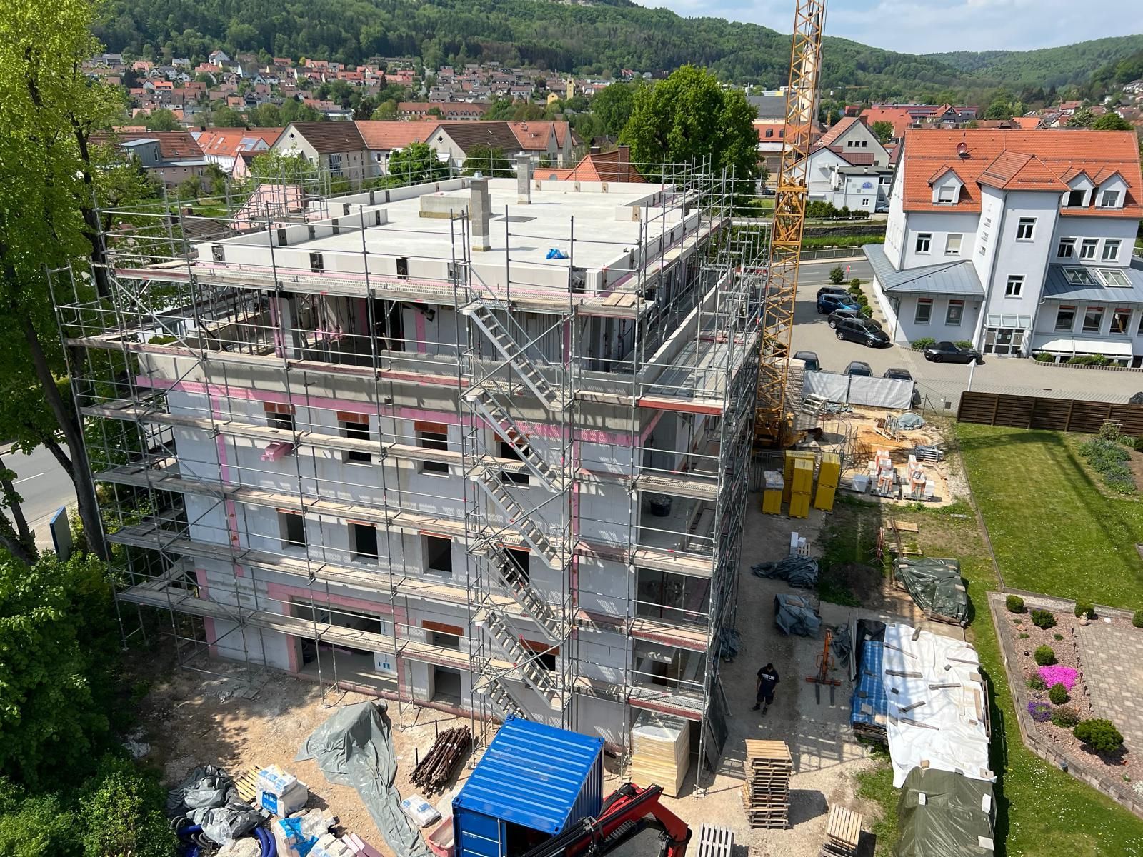 Eine Luftaufnahme eines im Bau befindlichen Gebäudes mit Gerüst und Kran.