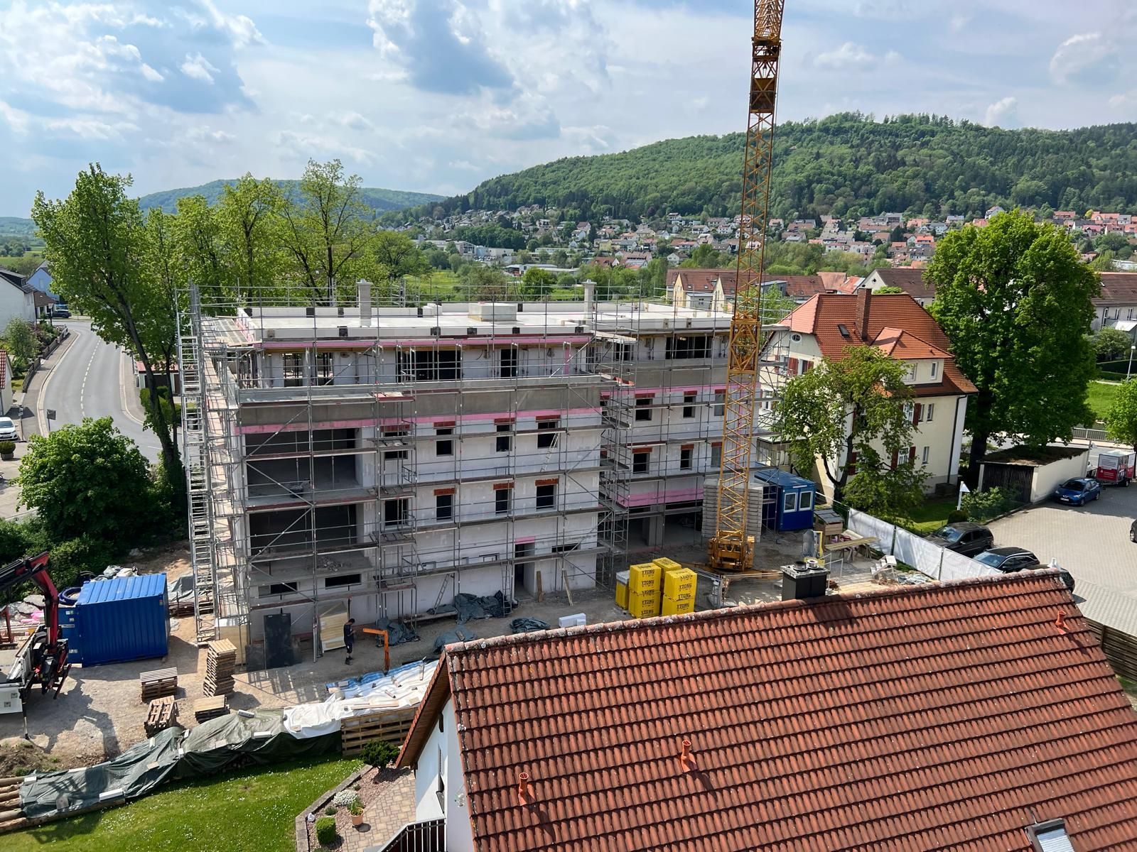 Eine Luftaufnahme eines im Bau befindlichen Gebäudes mit einem Kran im Hintergrund.