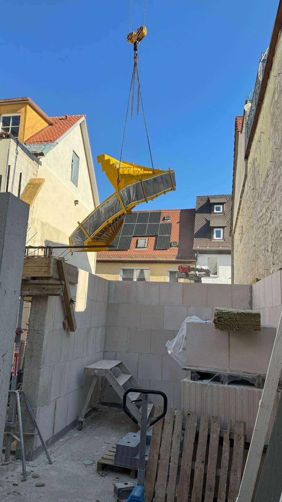 Ein Kran hebt ein großes Stück Beton in die Luft.